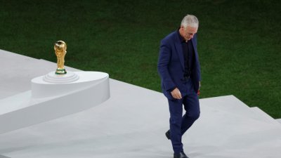 法国队主帅德尚在颁奖典礼上拿著银牌经过大力神杯时，神情明显看得出非常失落。（图取自法新社）