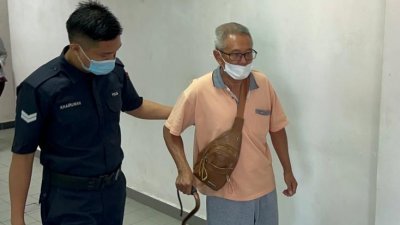 被告吴兴宏（右）手持拐杖出庭面控。