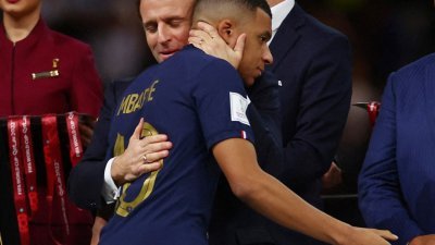 在卡塔尔世界杯的颁奖典礼上，法国总统马克龙“强拥”姆巴贝入怀，后者并未回抱他，反而显得很想要挣脱对方的拥抱。（图取自路透社）