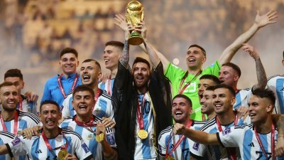 阿根廷18日在卡塔尔世界杯击败卫冕军法国，勇夺队史第3冠，梅西（中）手捧大力神杯欢呼。（路透社）
