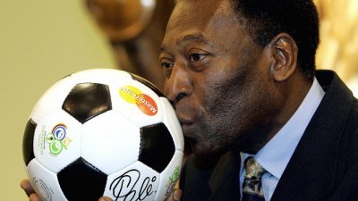 2005年12月8日，巴西足球传奇人物比利在2006年国际足联足球世界杯决赛抽签前夕，在莱比锡的一次演讲中亲吻了一个球。（图取自法新社档案照）