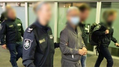 谢志乐（中）周四抵达墨尔本机场后由澳洲警方押解，他双手锁上手铐，预计在当地出庭。（图取自澳洲联邦警察网站）