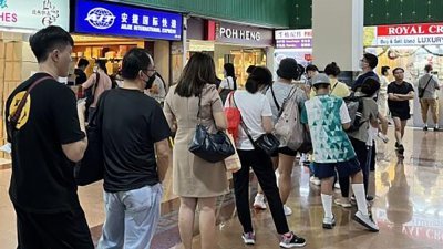 不少旅居新加坡的中国游子纷买药邮寄往老家亲友。图为安捷国际快递牛车水分店外排起了长龙。