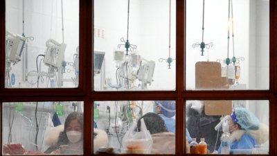 中国上海某家医院的医护人员在照料病人。（图取自路透社）