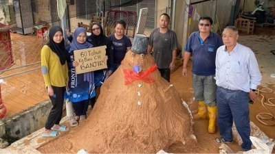 甘榜拉惹新村村民泥浆堆砌像雪人形态的“泥人”，以此方式冀相关单位正视该区洪灾问题。（取自社媒）