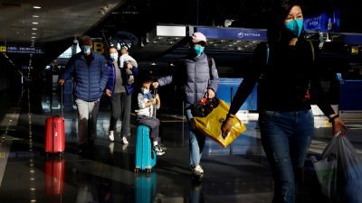 在中国北京国际机场，旅客拖著行李走过大厅。（图取自路透社）