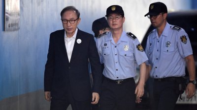 2018年9月6日，韩国前总统李明博（左）抵达首尔法庭出席对他的审判。（图取自法新社档案照）