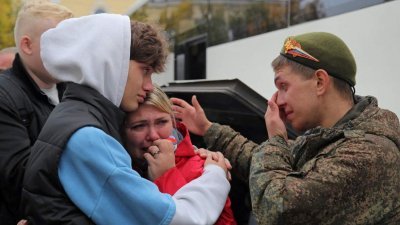 一名俄罗斯预备役军人随部分动员部队前往基地前，与亲属告别。（图取自路透社）