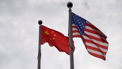 图为在上海的一座公司大楼外，飘扬著中国和美国国旗的档案照。（图取自路透社）