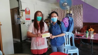 阮彩（左）于今年1月30日接领支票，并感激所有善心人士的援助。