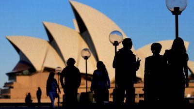 图为疫情爆发前，澳洲著名地标悉尼歌剧院附近，人们在日落时剪影的档案照。（图取自路透社）