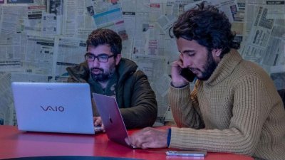 印度网媒喀什米尔瓦拉的创办人沙阿（右），在位克什米尔地区斯利那加县的办公室办公的画面。（图片取自网络）