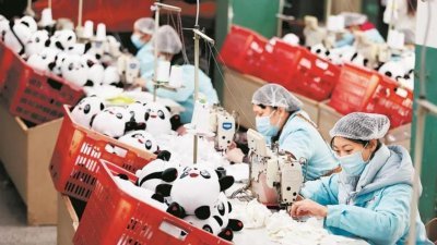 在晋江恒盛玩具车间，工人正在赶工生产“冰墩墩”。（图取自《福建日报》）