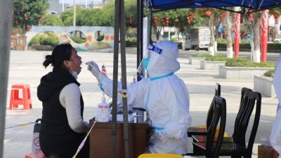 中国广西百色市封城，一名市民在进行核酸检测。（图取自中新社）