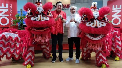 郑明傅（左）和萧斐弘与两头梳邦弘德体育会舞狮向大家拜年。
