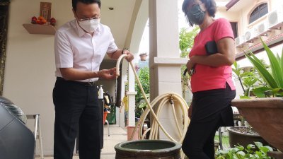 杨顺兴（左）巡视刘玉水居民住家，检查水喉供水时发现虽水管有流出水，惟其水量非常小。
