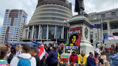 纽西兰示威群众日前聚集在首都惠灵顿的国会大厦外，反对政府强制施打新冠疫苗的政策。（图取自路透社）