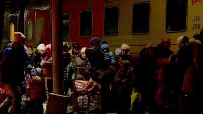 在顿涅茨克的Taganrog镇，当地居民周日在一辆列车外排队，准备被撤离到俄罗斯。（图取自法新社）