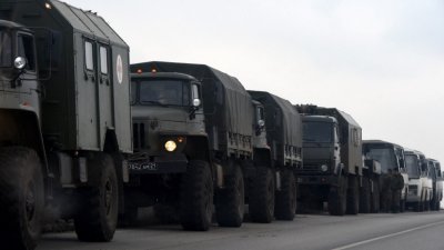 俄罗斯南部罗斯托夫地区的一条公路，当地时间周三出现了俄罗斯军用卡车和巴士，该地区与“顿涅茨克人民共和国”边境接壤。（图取自法新社）