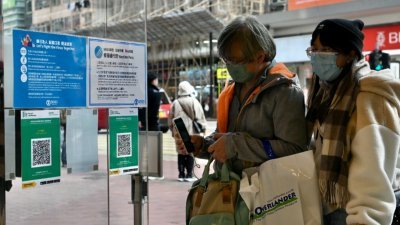 香港周四起实施“疫苗通行证”安排，市民扫瞄“安心出行”二维码进入百货商场。（图取自中新社）