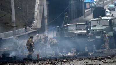 当地时间周六上午，乌克兰军人在首都基辅与俄罗斯袭击小组战斗，击退莫斯科的袭击后收集未爆炸的炮弹。（图取自法新社）