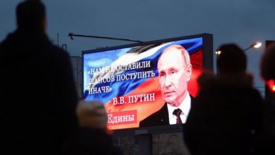 在俄罗斯第2大城圣彼得堡，旁观者聚集在一块展示俄罗斯总统普京的照片和他最近向全国发表讲话中的一句话的看板前，上面写著：“我们没有其他机会，只能采取不同的行动。”（图取自法新社）