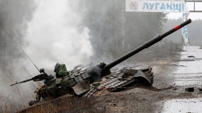 在卢甘斯克地区的一条路边，一辆被乌克兰军队摧毁的俄罗斯坦克周六冒出浓烟。（图取自法新社）