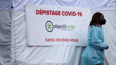 医务人员在法国巴黎一家药房外的新冠病毒检测亭，等待民众前来进行采样检测。（图取自路透社）