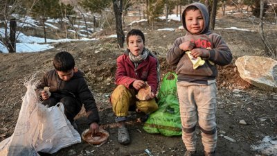 在阿富汗Wazir Akbar Khan山上，数名儿童吃著面包。（图取自法新社）

