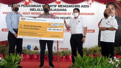 凯里（左2）移交700万令吉的支票予马来西亚爱滋病协会，由李国忠（左）接领。右起为沙阿里以及沙菲宜。