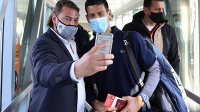被澳洲驱逐出境的网球“一哥”佐科维奇（中）当地时间周一返抵塞尔维亚，在机场时他与一名男子。（图取自路透社）