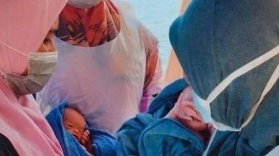 原住民妇女在船上平安诞下一对男婴双胞胎，令接生护士也充满喜悦。（取自霹雳州卫生局面子书）