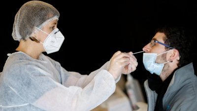 医务人员在法国南特市的一个检测中心，为患者采样进行新冠病毒检测。（图取自路透社）