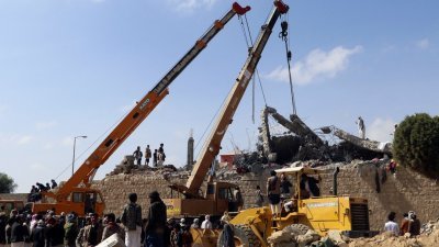 也门萨达一所临时拘留中心周五遭遇空袭，报导说最少70人死亡，过百人受伤。图为救援人员使用起重机，拆除拘留中心倒塌的混凝土屋顶，以寻找抢救生还者。（图取自路透社）
