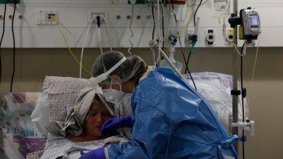 在以色列北部城市采法特的医疗中心，一名医务人员在新冠肺炎隔离病房内照顾一名 患者。（图取自法新社）