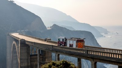 在加州大苏尔的当地著名地标比克斯比大桥，可见到消防人员。（图取自路透社）