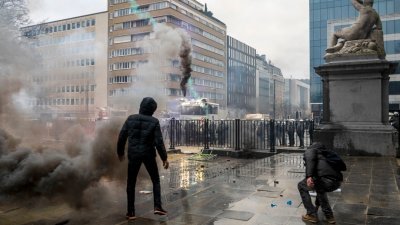 一名示威者站在警察面前，抗议比利时和其他欧洲国家采取的防疫措施。（图取自法新社）