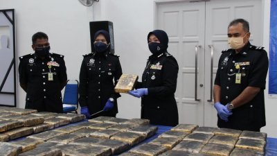 苏丽娜（右2）展示警方充公的大麻砖。
