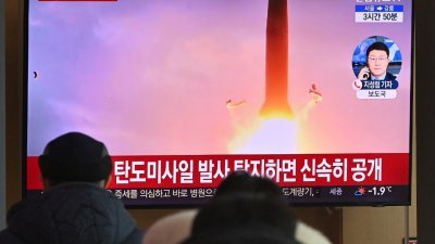 韩国民众周日早在首尔火车站，看著电视播报朝鲜试射导弹的新闻画面。（图取自法新社）