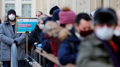 俄罗斯民众戴著口罩，排队等候接种新冠疫苗。（路透社档案照）