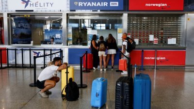 在西班牙马拉加-太阳海岸机场，瑞安航空的乘客本月1日在空乘人员罢工期间，在瑞安航空的信息台等待信息。（图取自路透社）