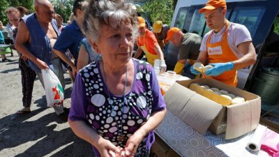 在卢甘斯克地区的北顿涅茨克市，志愿者在上周四向当地居民分发食物。（图取自路透社）