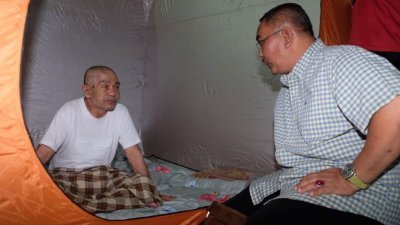 沙努西（右）夜访临时疏散中心，慰问其中一名灾黎。
