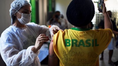 去年7月在里约热内卢最著名的旅游景点之一伊利亚格兰德岛，一名卫生工作者为一名居民注射一剂强生（Johnson & Johnson）新冠肺炎疫苗。（图取自路透社档案照）
