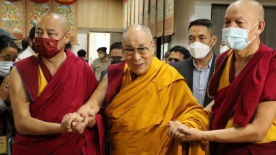 西藏流亡政府精神领袖达赖喇嘛（中）在旁人搀扶下于周三抵达达兰萨拉，参加他87岁生日的博物馆落成典礼。（图取自法新社）
