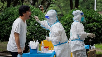 一名北京市民周三接受医护人员的新冠病毒核酸检测。（图取自路透社）