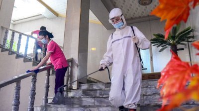 朝鲜官媒上周六发布的照片显示，工作人员正在消毒，以防止新冠肺炎病毒在平壤一家酒店传播。（图取自朝中社/法新社）