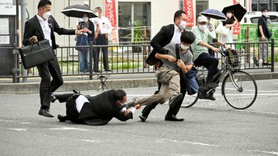 凶嫌山上彻也向日本前首相安倍晋三开了两枪后，被警方扑倒。（图取自朝日新闻/路透社）