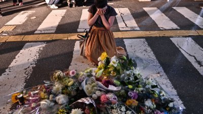 日本前首相安倍晋三上周五遭枪杀身亡，当晚在案发地点有前来吊唁的民众现场掩面痛哭落泪。（图取自法新社）