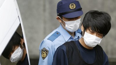 杀害日本前首相安倍晋三的凶嫌山上彻也，10日在警方的护送下被带往检察院。（图取自共同社/路透社）